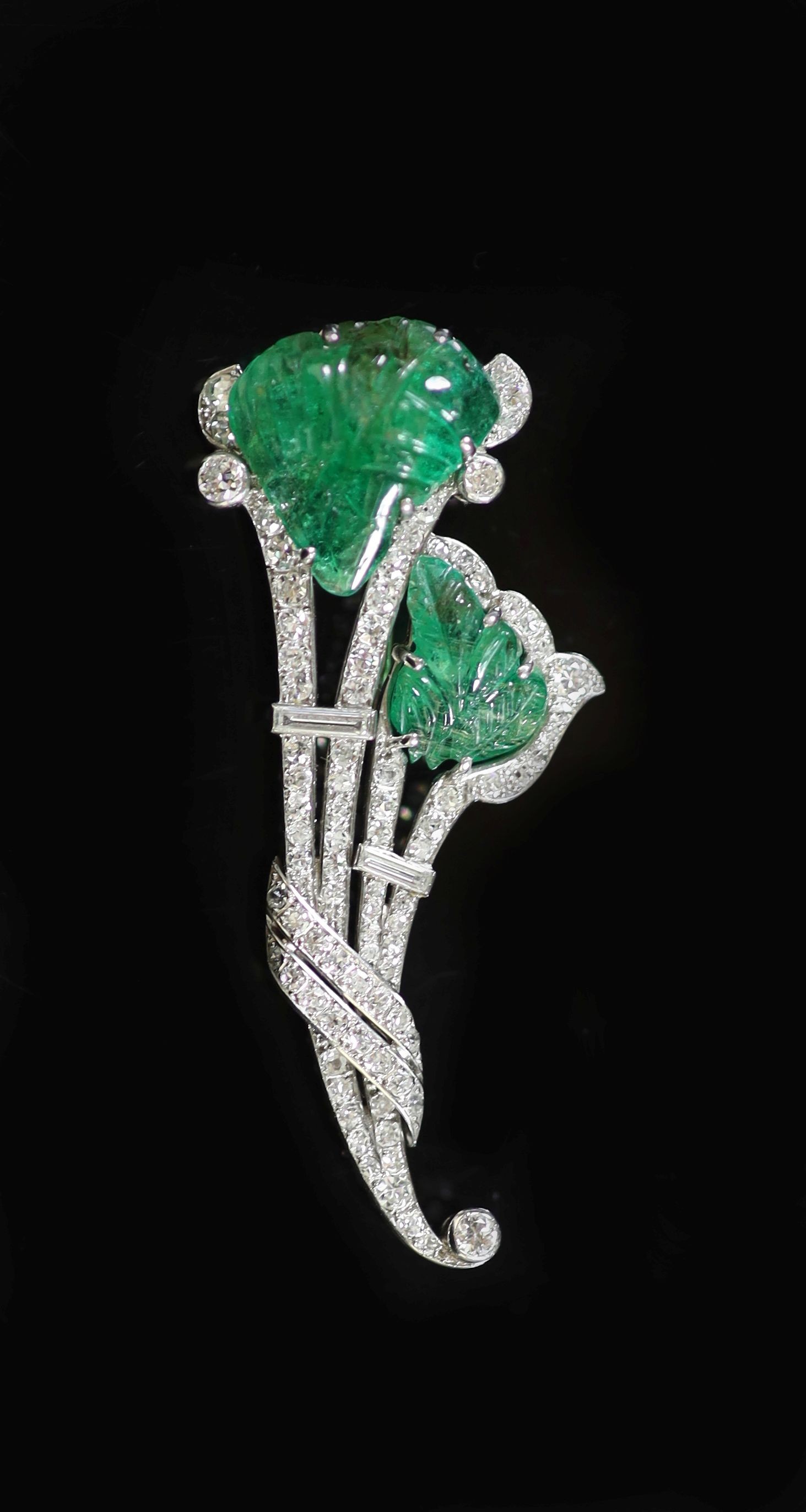 A 1940's French 18ct white gold, carved emerald, baguette and round cut diamond set floral spray brooch(a.f.)